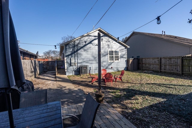 rear view of house featuring central air condition unit and a wooden deck