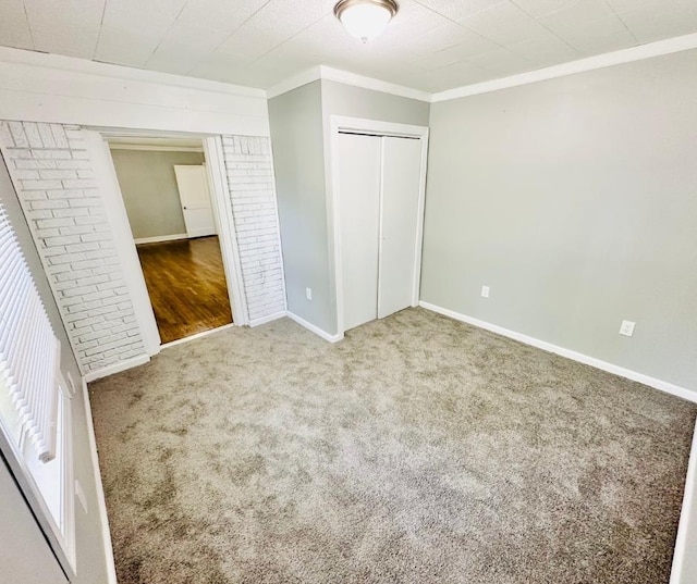 unfurnished bedroom featuring a closet, ornamental molding, and carpet floors