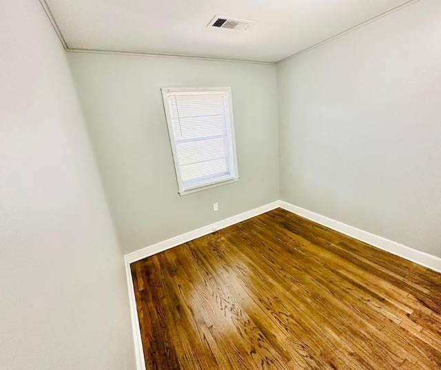 spare room with hardwood / wood-style flooring and ornamental molding