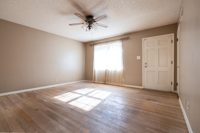 unfurnished room featuring ceiling fan, light hardwood / wood-style flooring, and a textured ceiling