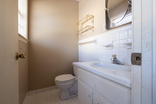 bathroom featuring toilet, tile patterned floors, a wealth of natural light, and vanity