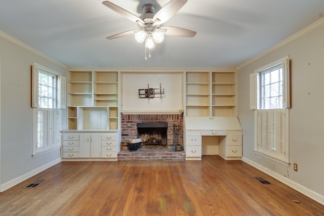 unfurnished living room featuring a fireplace, ceiling fan, a healthy amount of sunlight, and ornamental molding