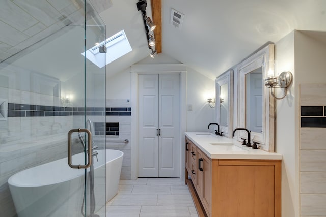 bathroom featuring a washtub, tile patterned flooring, vanity, tile walls, and vaulted ceiling with skylight