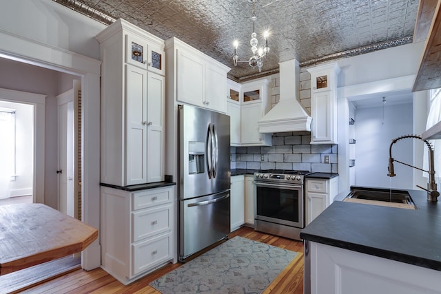 kitchen featuring sink, custom range hood, decorative backsplash, brick ceiling, and appliances with stainless steel finishes