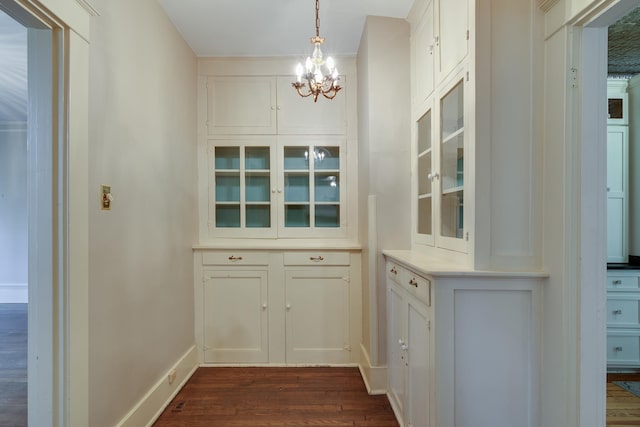 interior space featuring a notable chandelier, white cabinets, decorative light fixtures, and dark hardwood / wood-style floors