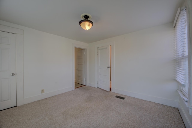 unfurnished bedroom with light colored carpet