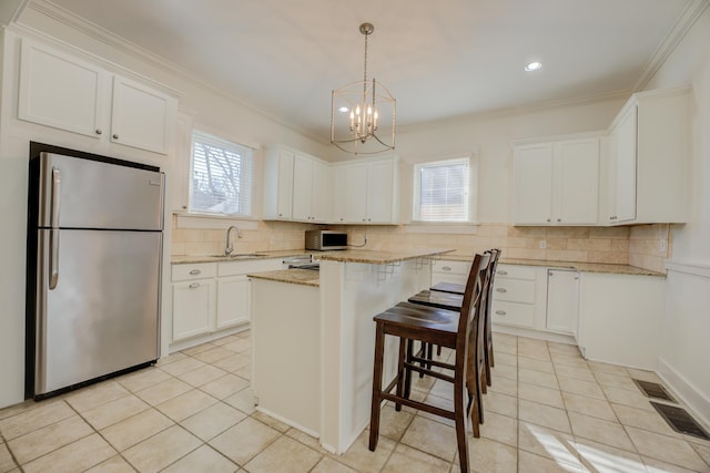 kitchen featuring white cabinets, stainless steel appliances, sink, and a kitchen island