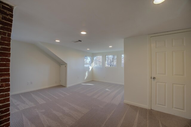 additional living space featuring light carpet