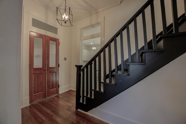 entryway featuring dark hardwood / wood-style flooring, an inviting chandelier, and crown molding