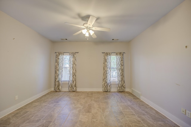 unfurnished room with ceiling fan and a wealth of natural light