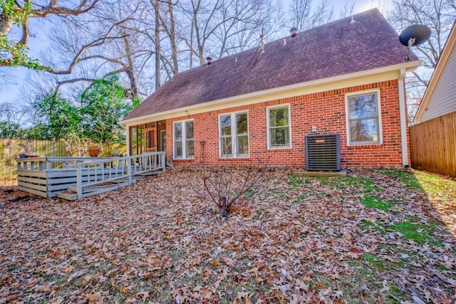 rear view of house featuring cooling unit and a wooden deck