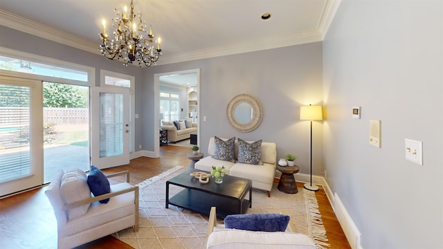 living area with crown molding, light wood-style flooring, and baseboards