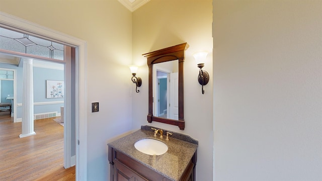 bathroom featuring wood finished floors, vanity, visible vents, and baseboards