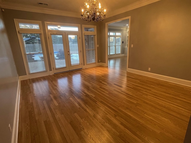 interior space with baseboards, visible vents, wood finished floors, and ornamental molding