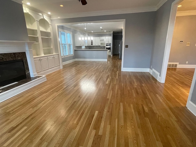 unfurnished living room featuring a fireplace, visible vents, ornamental molding, dark wood-type flooring, and baseboards