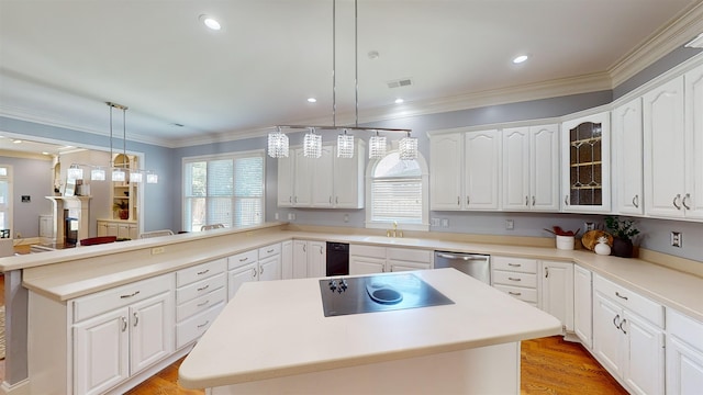 kitchen with black electric stovetop, a peninsula, a kitchen island, a sink, and stainless steel dishwasher