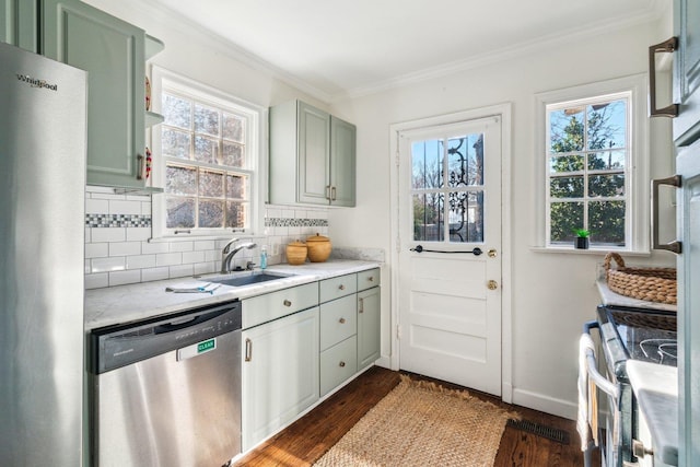 kitchen with appliances with stainless steel finishes, dark hardwood / wood-style flooring, sink, backsplash, and crown molding