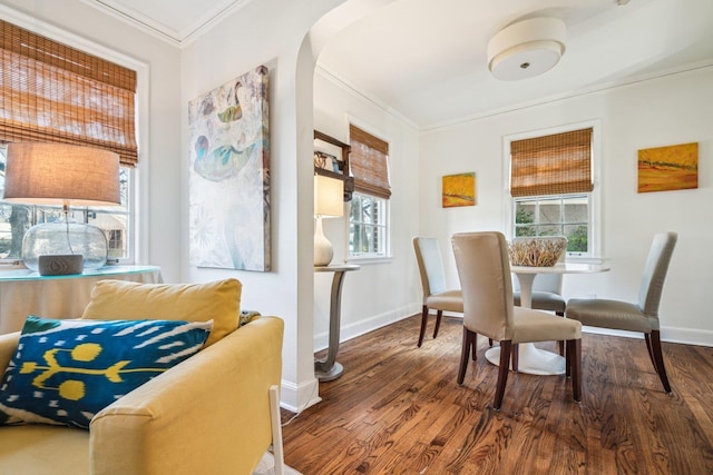 dining space featuring wood-type flooring and crown molding