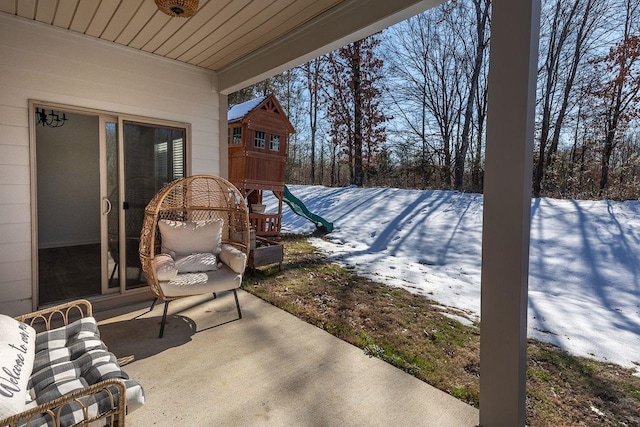 snow covered patio featuring a playground