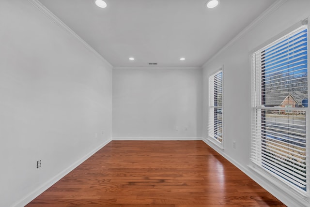 empty room featuring hardwood / wood-style flooring and crown molding