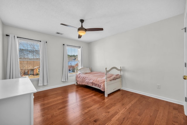 bedroom featuring ceiling fan, a textured ceiling, and hardwood / wood-style floors