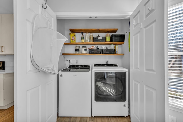 laundry room featuring washer and clothes dryer and light hardwood / wood-style flooring