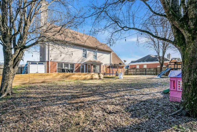 rear view of property with a playground