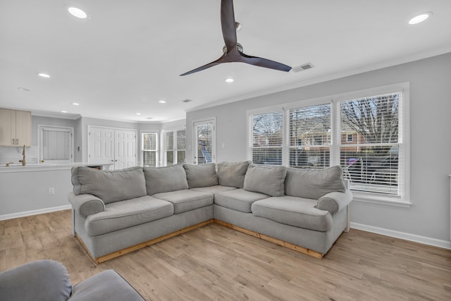 living room featuring ceiling fan, light hardwood / wood-style flooring, crown molding, and a healthy amount of sunlight