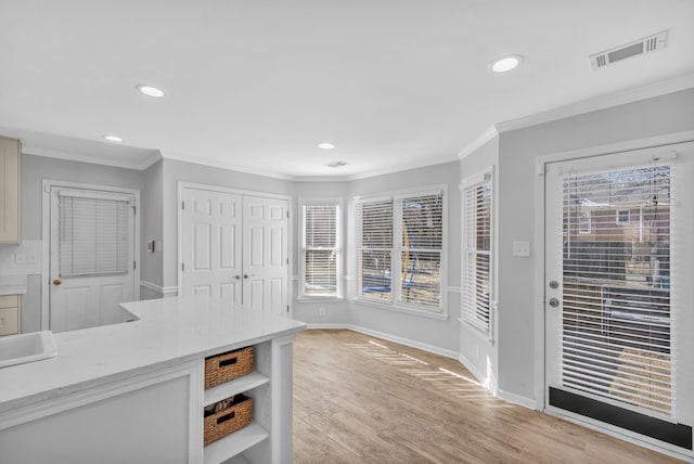 kitchen featuring ornamental molding and light wood-type flooring