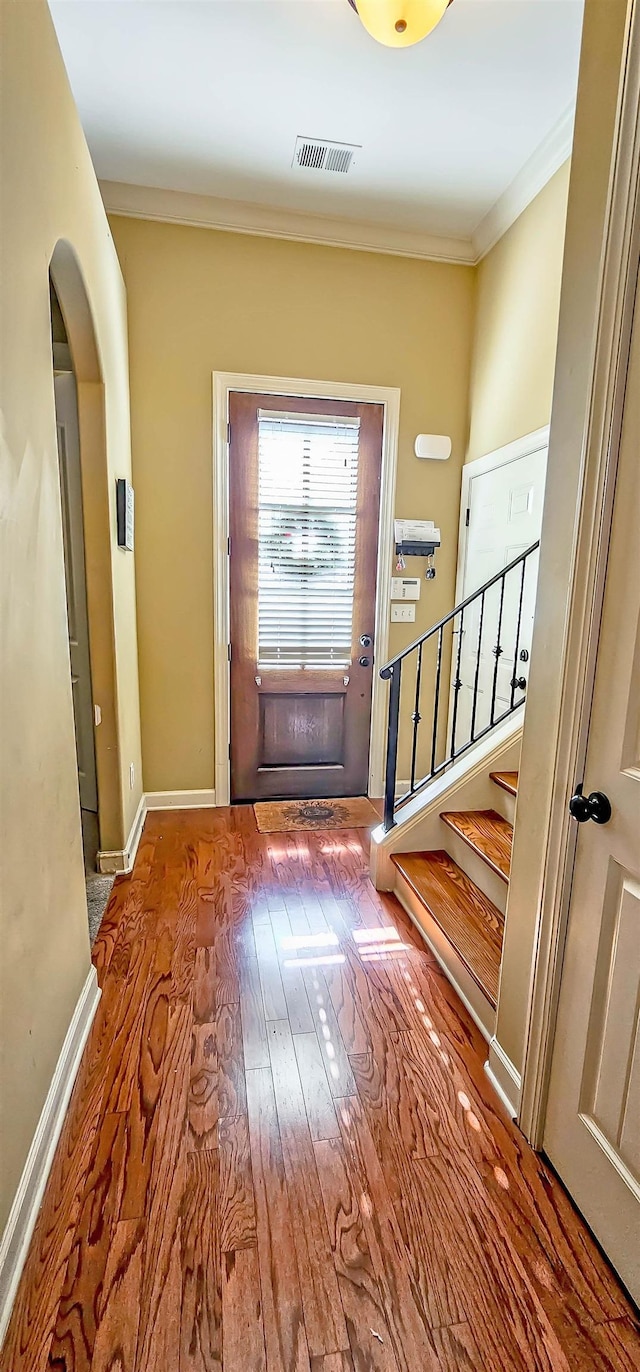 entryway featuring ornamental molding and wood-type flooring