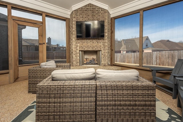 sunroom with lofted ceiling and a brick fireplace