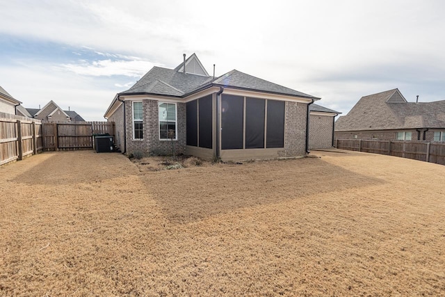 rear view of house featuring central AC and a sunroom