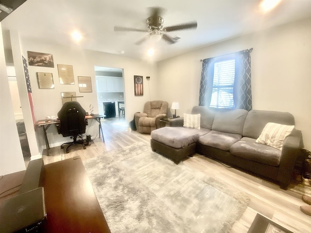 living room with light hardwood / wood-style floors and ceiling fan