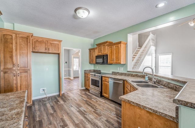 kitchen featuring a healthy amount of sunlight, sink, stainless steel appliances, and a textured ceiling