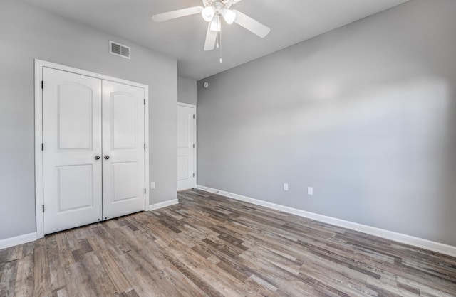 unfurnished bedroom featuring ceiling fan, a closet, and hardwood / wood-style flooring