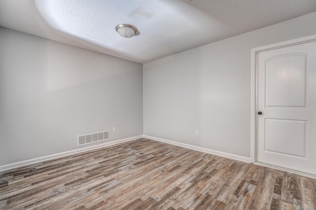 spare room with hardwood / wood-style flooring and a textured ceiling