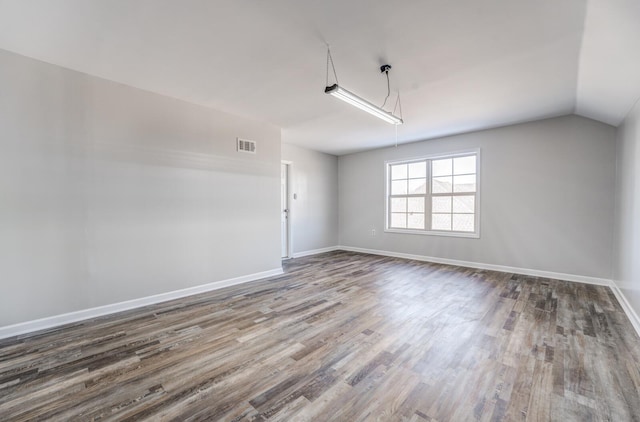 unfurnished room with lofted ceiling and hardwood / wood-style floors