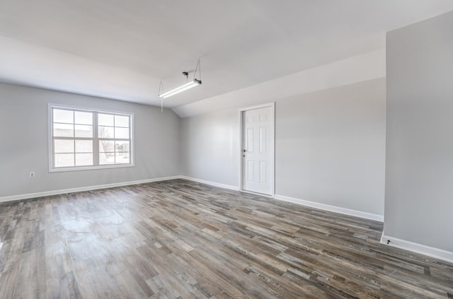 unfurnished room with dark wood-type flooring and lofted ceiling