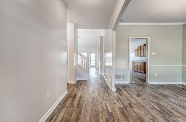 hallway with dark hardwood / wood-style flooring and ornamental molding