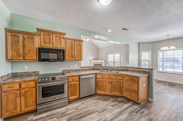 kitchen featuring appliances with stainless steel finishes, sink, a textured ceiling, and a notable chandelier