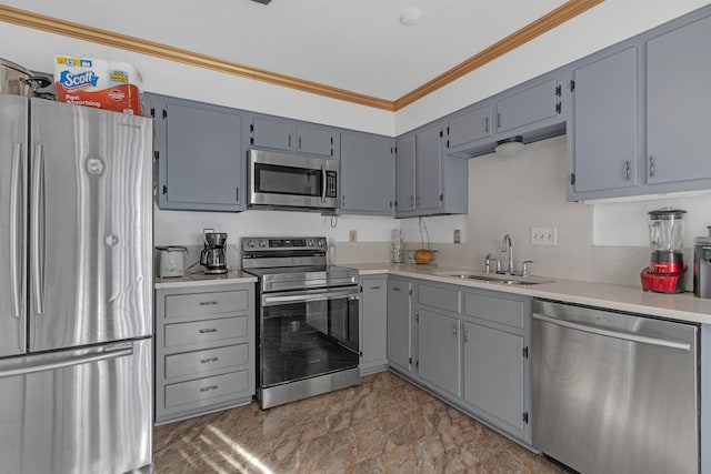 kitchen featuring appliances with stainless steel finishes, sink, gray cabinetry, and ornamental molding