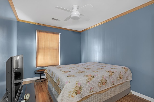 bedroom with ceiling fan, hardwood / wood-style flooring, and ornamental molding