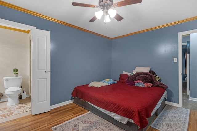 bedroom featuring ceiling fan, ensuite bath, hardwood / wood-style floors, and crown molding