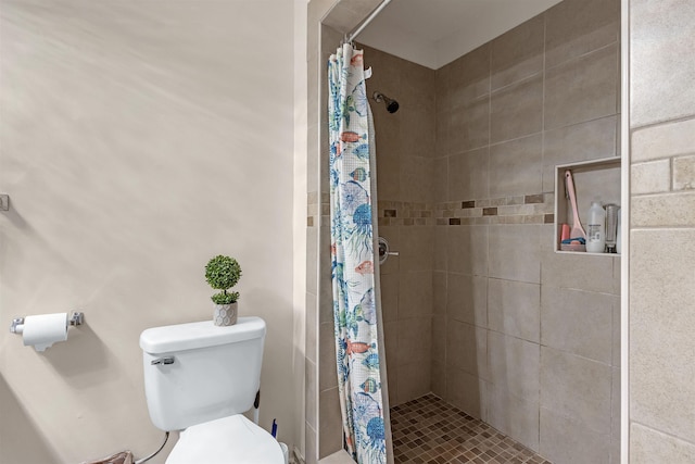 bathroom featuring toilet and curtained shower