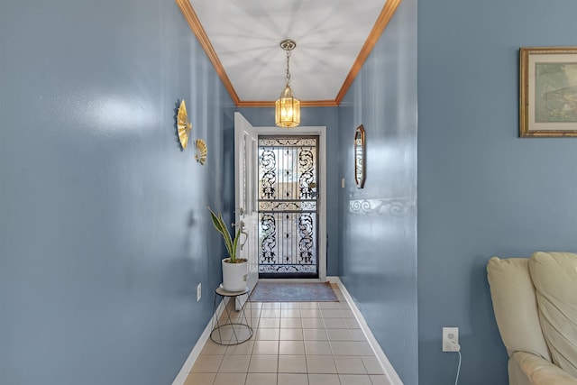 tiled foyer entrance with ornamental molding and an inviting chandelier