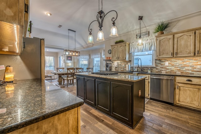 kitchen featuring a kitchen island, pendant lighting, sink, stainless steel appliances, and dark hardwood / wood-style flooring