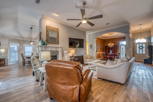 living room featuring plenty of natural light, light hardwood / wood-style flooring, and a stone fireplace