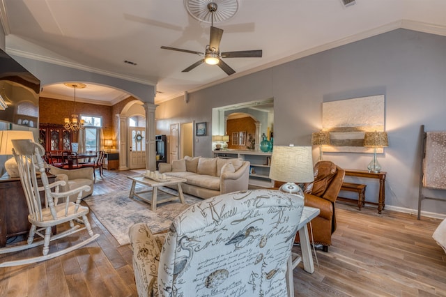 living room featuring crown molding, ceiling fan with notable chandelier, hardwood / wood-style flooring, and decorative columns