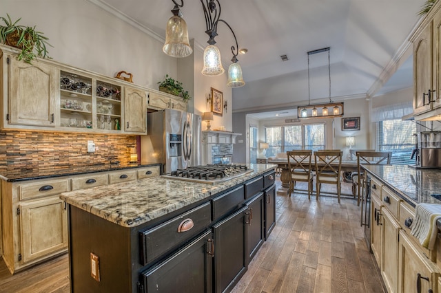 kitchen with stainless steel appliances, dark brown cabinets, hanging light fixtures, vaulted ceiling, and a kitchen island