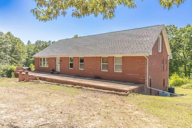 rear view of property featuring central AC unit, a patio area, and a yard